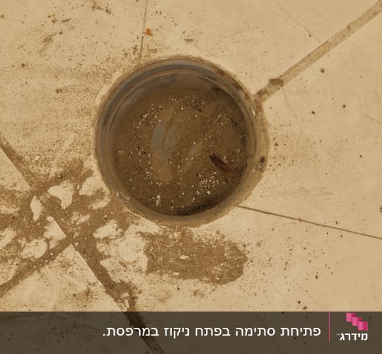 פתח ניקוז על רצפה עם לכלוך